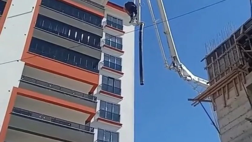 Beton pompasının üzerinde metrelerce yüksekliğe çıkan işçi, adeta ölüme meydan okudu